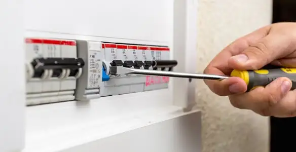 electrical panel upgrade service showing technician adjusting circuit breakers during system upgrade in Olathe, KS