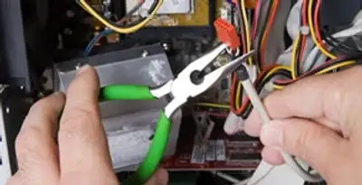 Licensed electrical contractor performing electrical repair with tools in New Century, KS