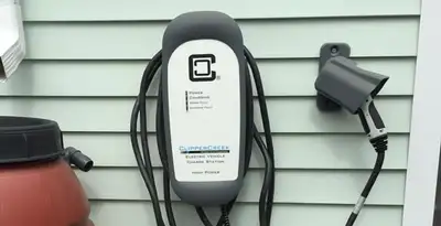 Outdoor electric vehicle charger installation on residential wall in Olathe, KS